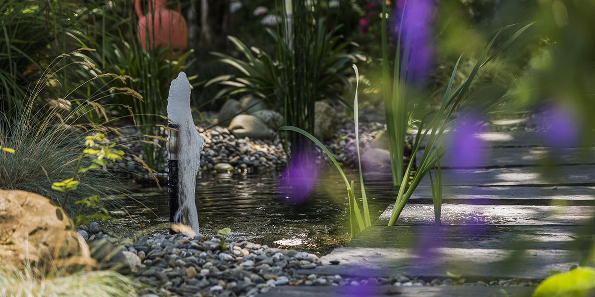 Bassin avec un jet d'eau installé par un paysagiste